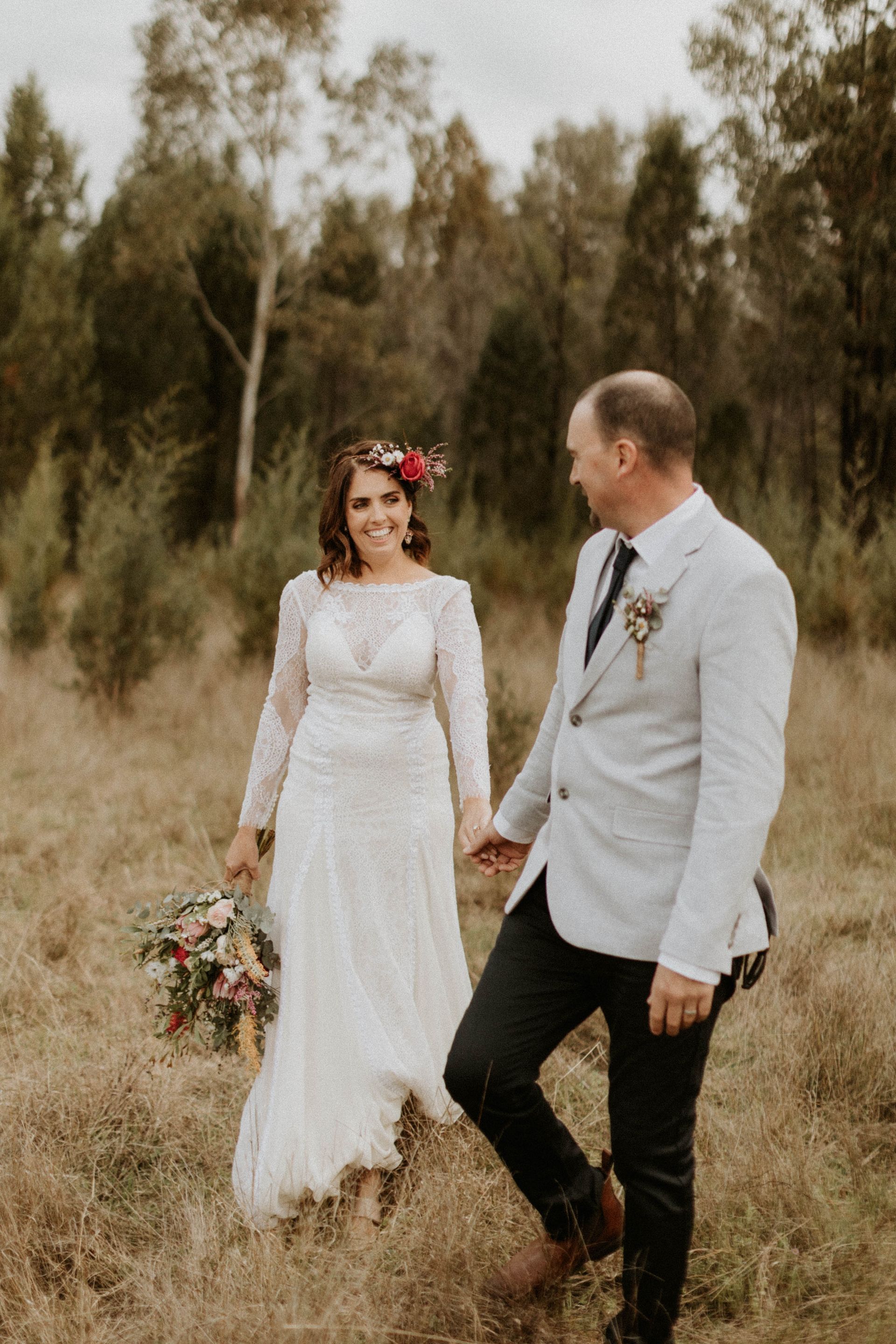 Bride and Groom Hold Hands — Denise's Flower Studio In Dubbo, NSW