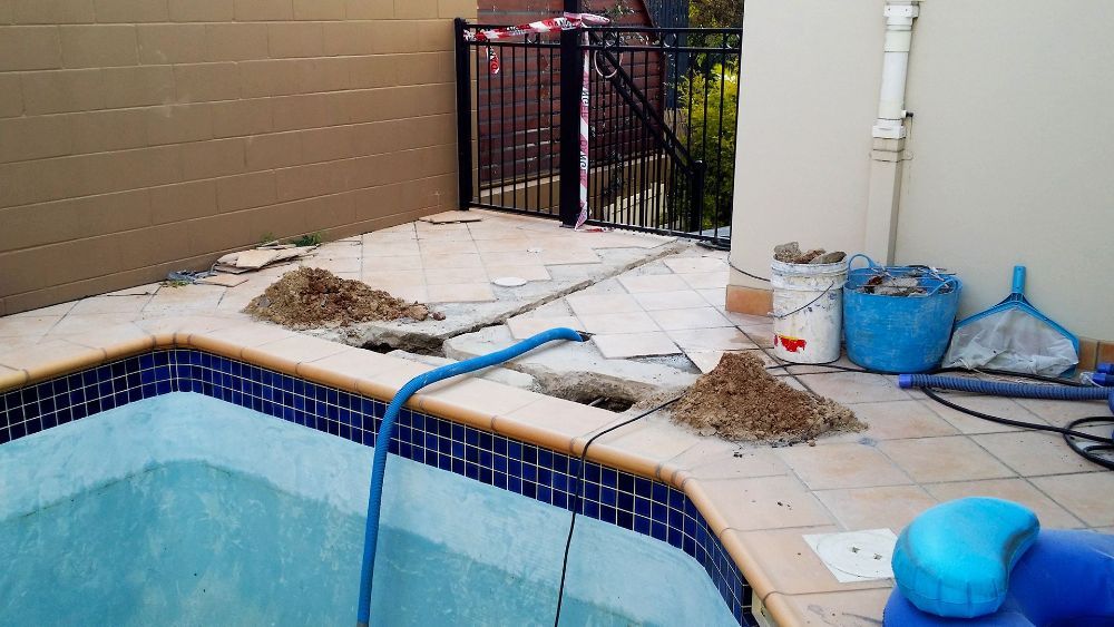 A Swimming Pool is Being Remodeled With a Blue Hose — NQ Tropical Pools & Renovations in Airlie Beach, QLD