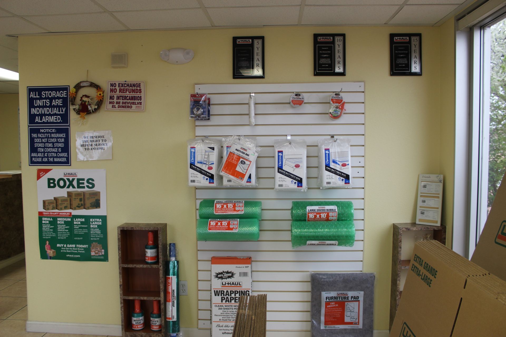 Storage facility office with packing supplies on display, beige walls, and boxes.