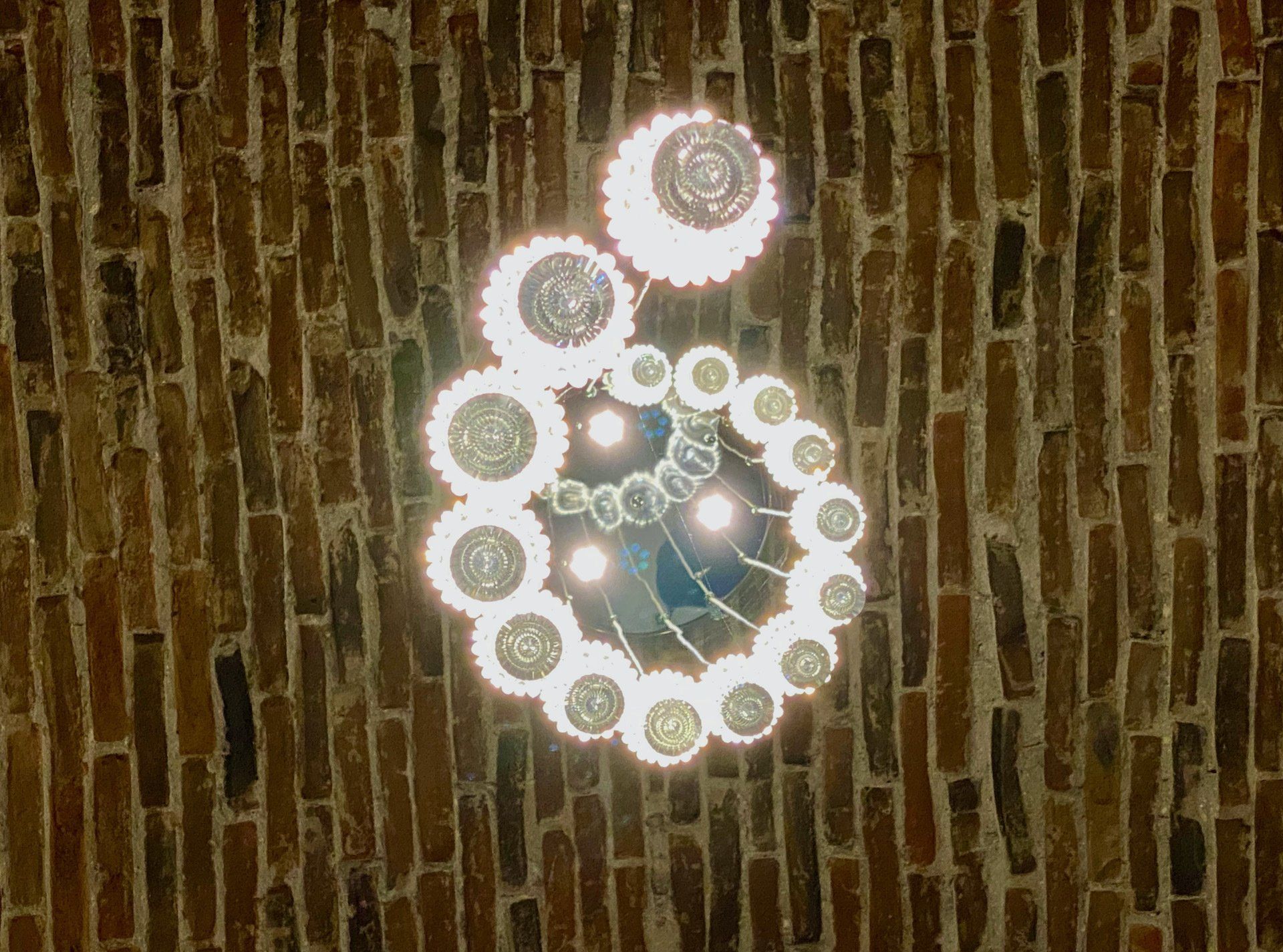 White circular lights arranged in a spiral on a brick wall at night