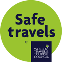 Safe Travels logo on lime green circle with World Travel & Tourism Council badge