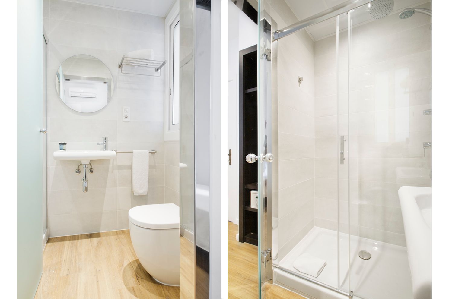 Baño moderno y luminoso con accesorios blancos, suelo de madera, lavabo, inodoro y mampara de ducha de cristal.