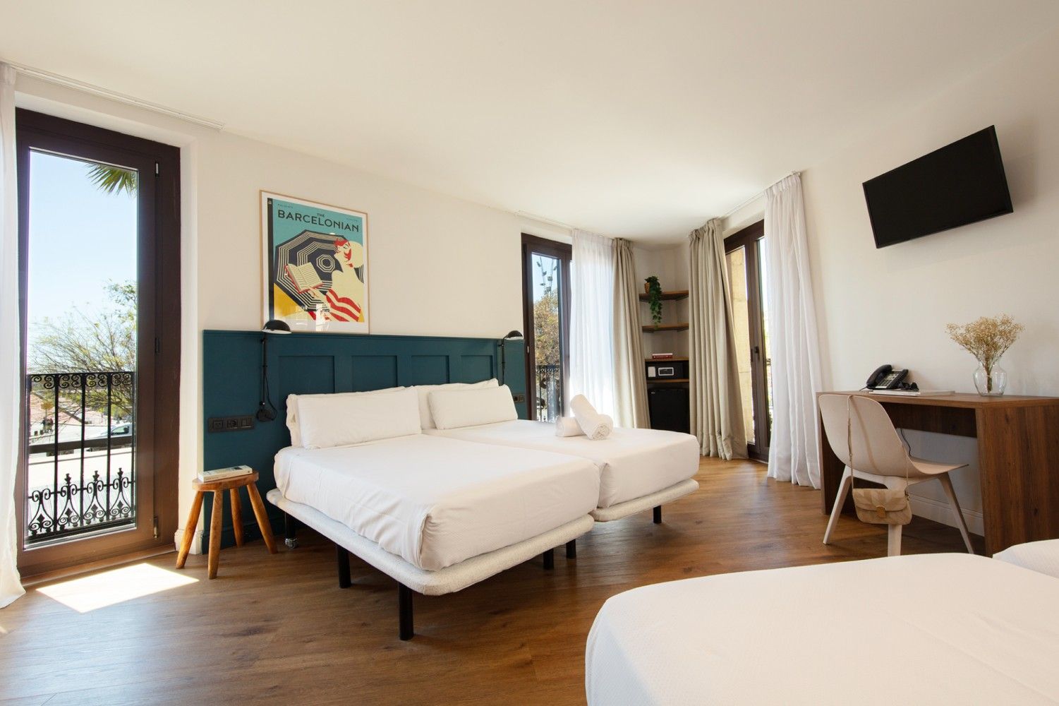 Una luminosa habitación de hotel con dos camas individuales juntas, un escritorio con silla.