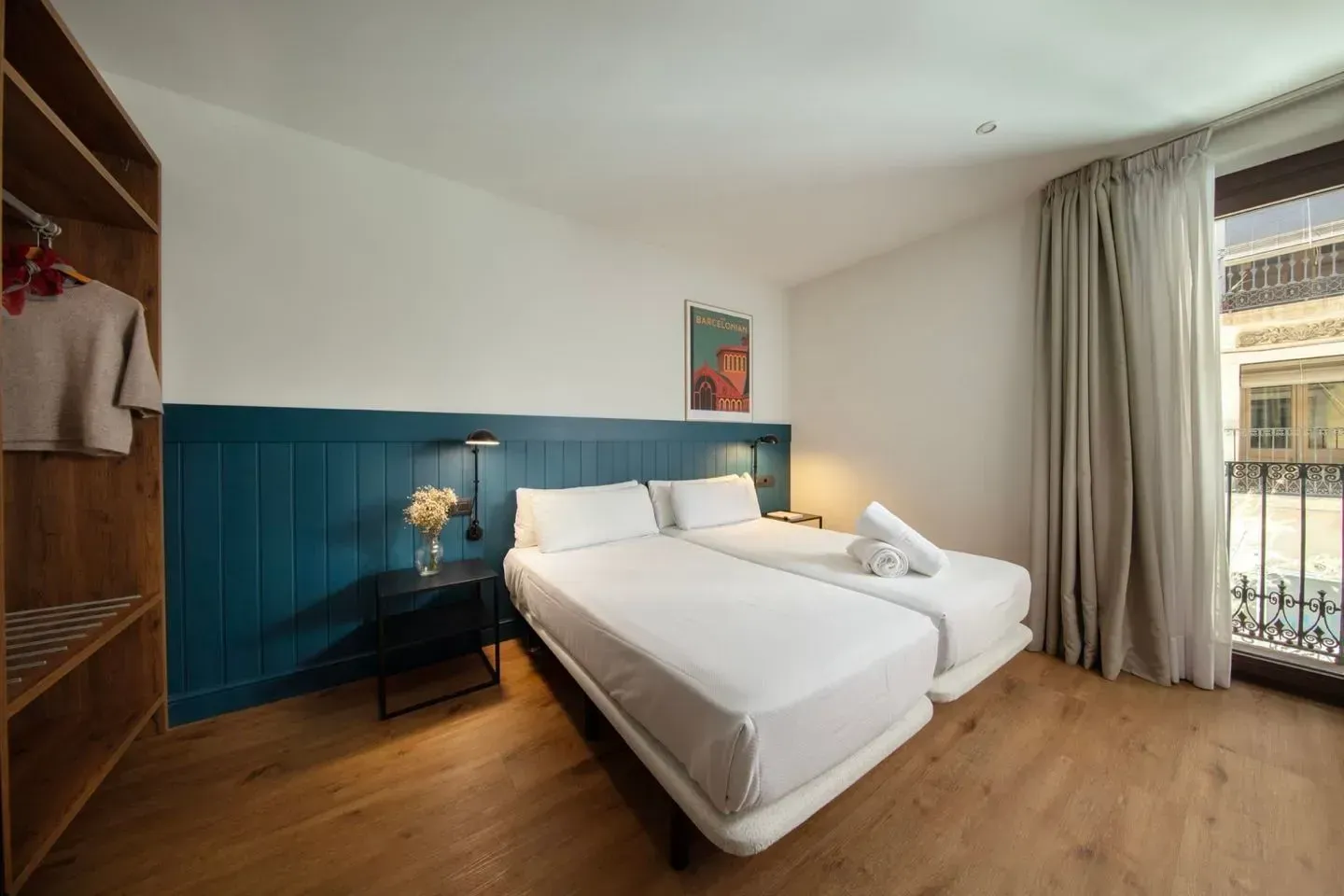 Una moderna habitación de hotel con dos camas individuales, revestimiento de madera azul, un armario de madera .