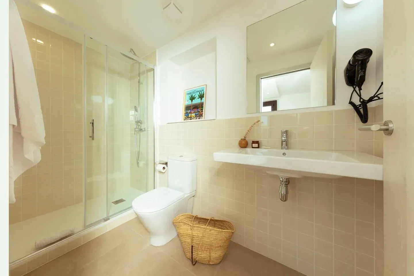 Baño moderno con ducha con mampara de cristal, lavabo blanco montado en la pared, inodoro .