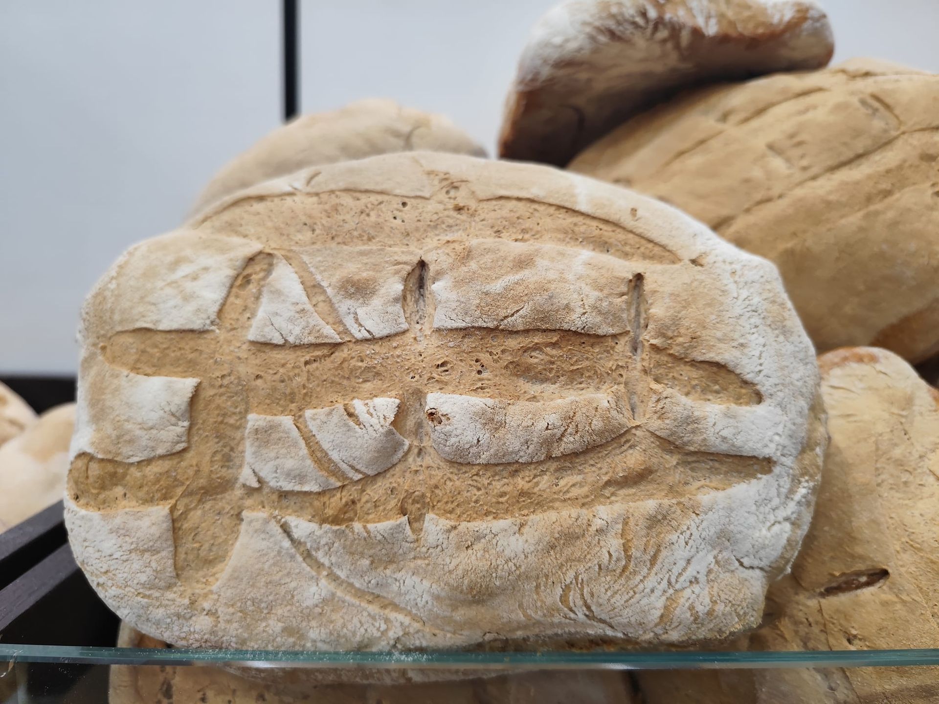 Una pagnotta di pane è appoggiata su uno scaffale di vetro.