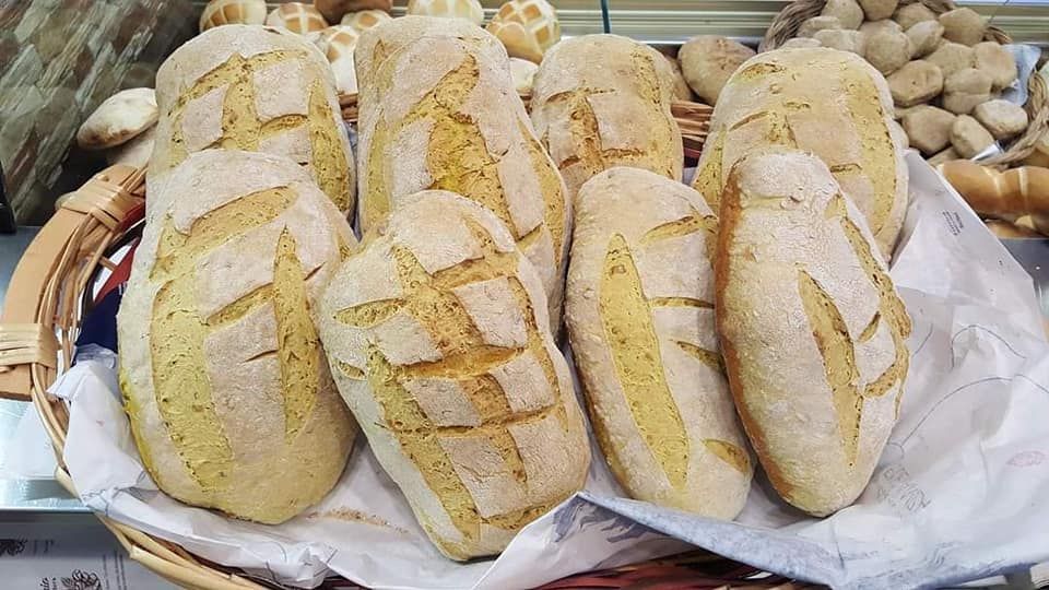 Un cestino di pane è appoggiato su un tavolo.