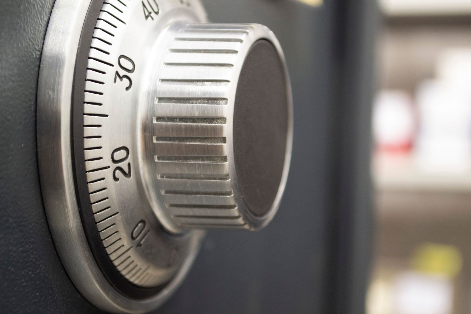 Close-up of a silver combination safe dial with numbers and a textured knob.