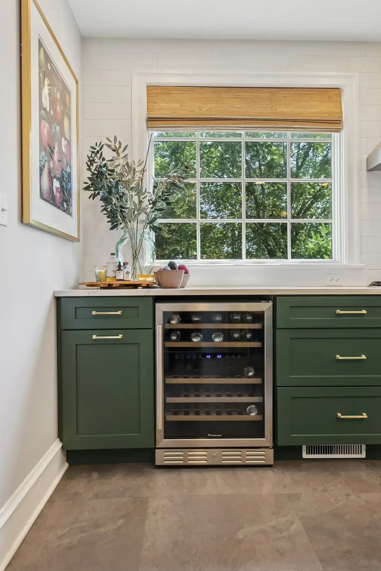 A kitchen with green cabinets and a wine cooler.