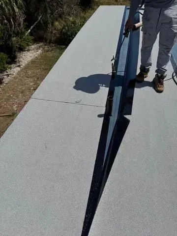 Person inspecting a long dark crack in a light gray walkway outdoors
