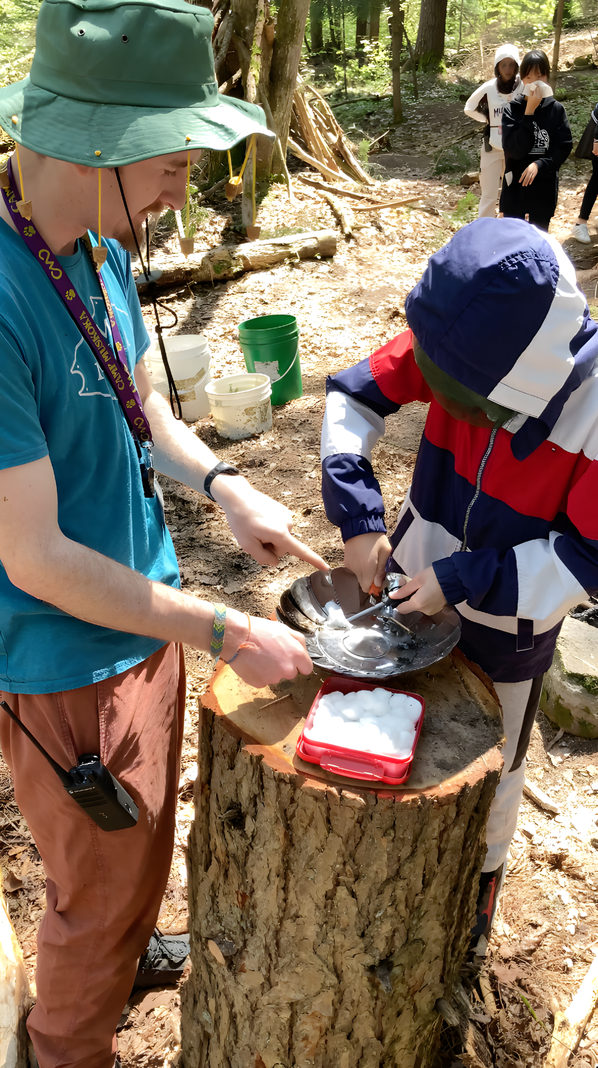 A boy and a girl are standing next to each other on a log.