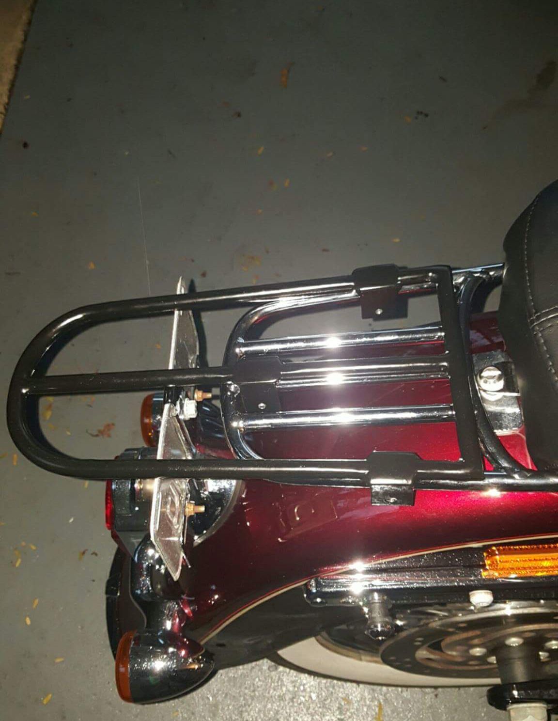Black luggage rack on a red motorcycle, with chrome bars and a black backrest.
