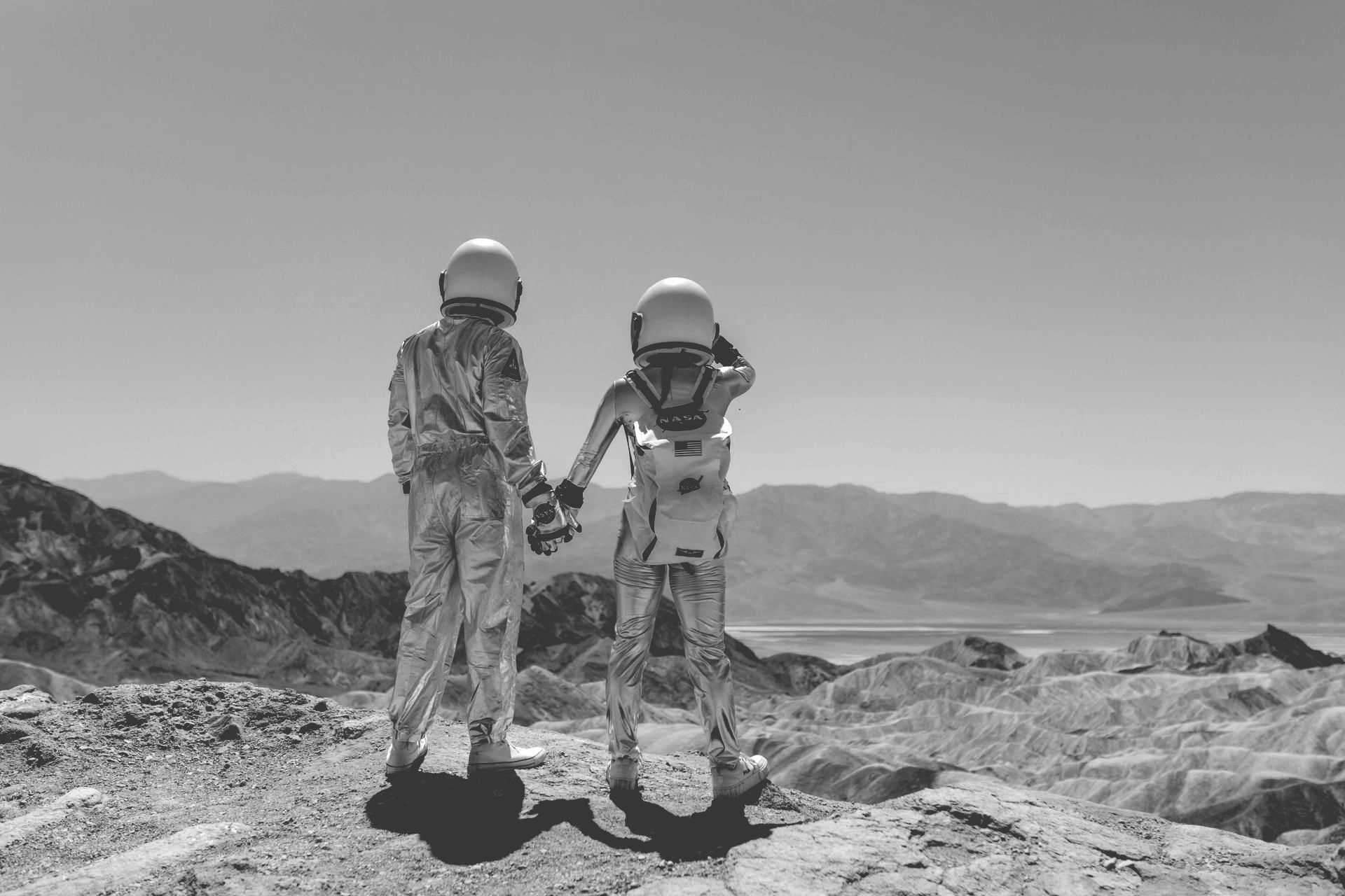 Twee vervreemde partners staan ​​hand in hand op de top van een berg.