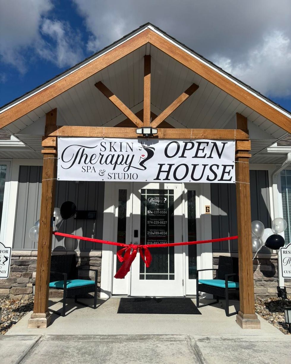 Skin Therapy Spa open house sign on a building entrance with red ribbon across the doorway