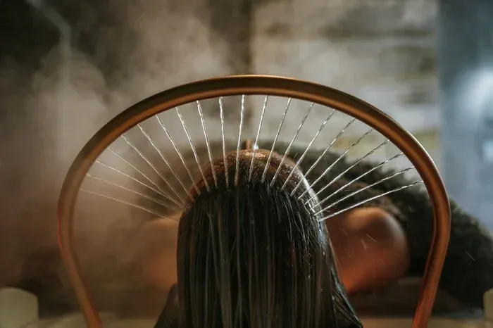 Woman receiving a facial mask with cucumber slices over closed eyes in a spa treatment
