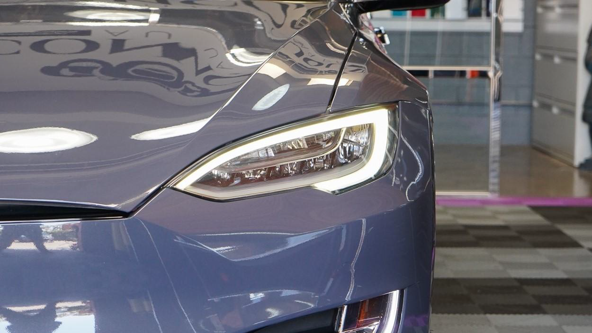 A close up of a tesla model s parked in a garage.