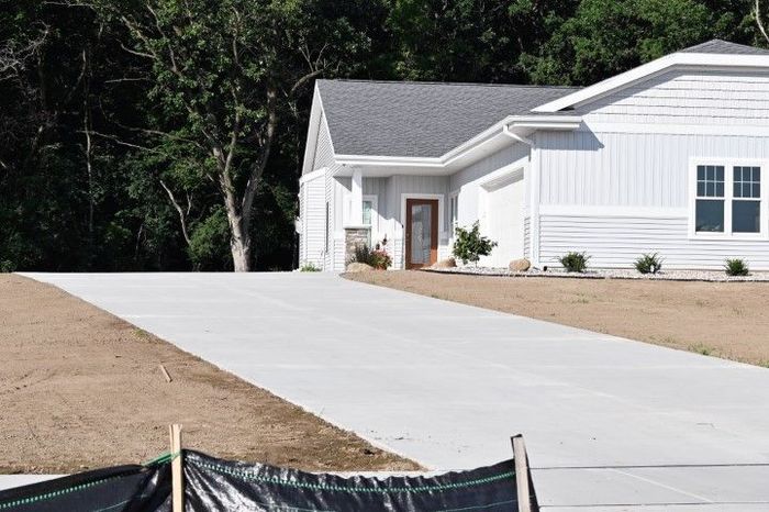 House with concrete driveway in a suburban setting.