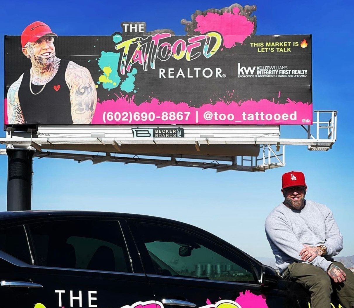 Billboard ad for The Tattooed Realtor with phone number and Instagram handle above a black SUV.