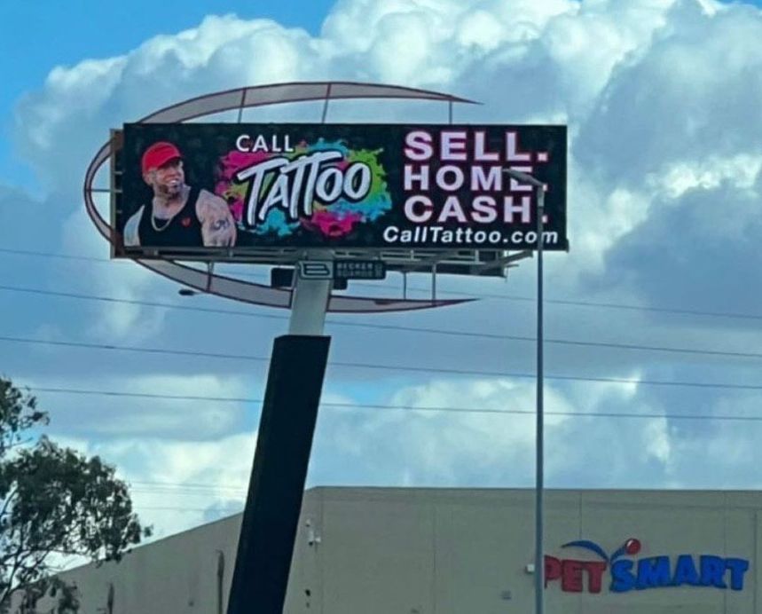 Billboard advertising Cali Tattoo: “Sell home cash” against a blue sky