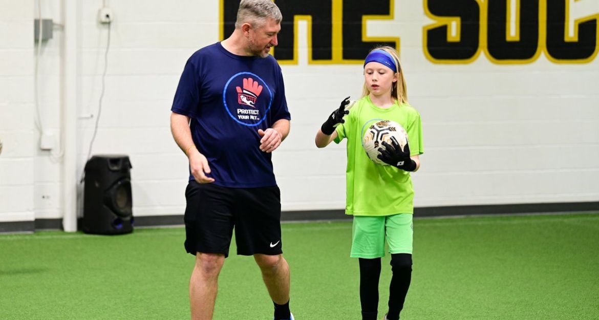 Coach Zach coaching a young girl goalkeeper