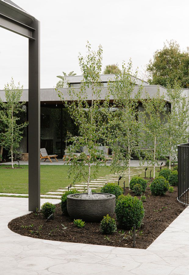 Luxury backyard pool with lounge seating under a pergola and steps leading to pool.