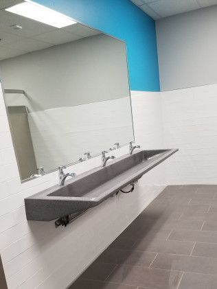 A bathroom with a long sink and a large mirror.