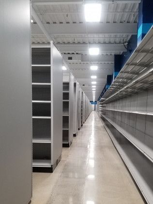 A long hallway with empty shelves in a store.