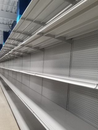 A long row of empty shelves in a store.