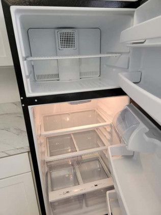 The inside of an empty refrigerator with the door open.