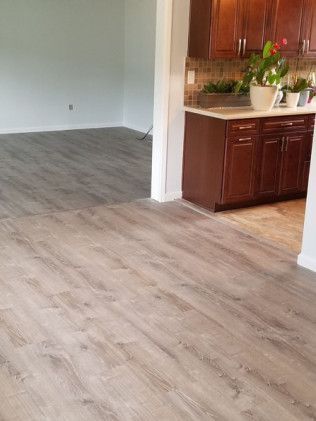 A kitchen with hardwood floors and wooden cabinets.