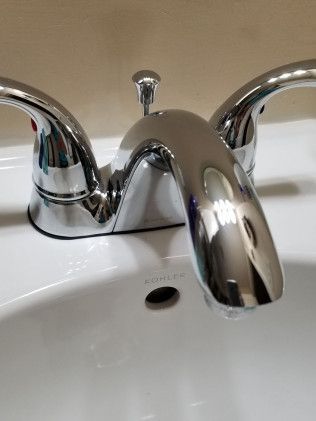 A close up of a bathroom sink with a chrome faucet.