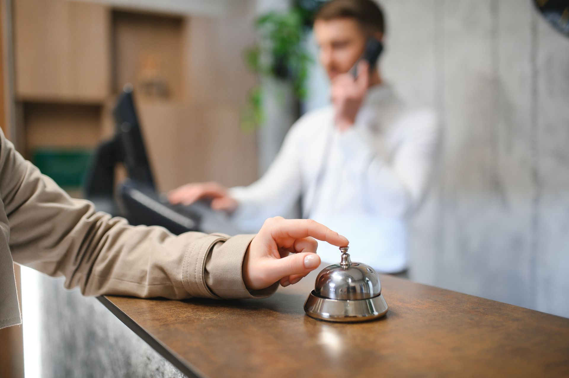 Uma mão tocando o sino de um hotel