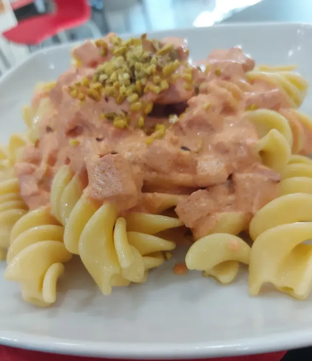 Un piatto di pasta con sugo e pistacchi sopra