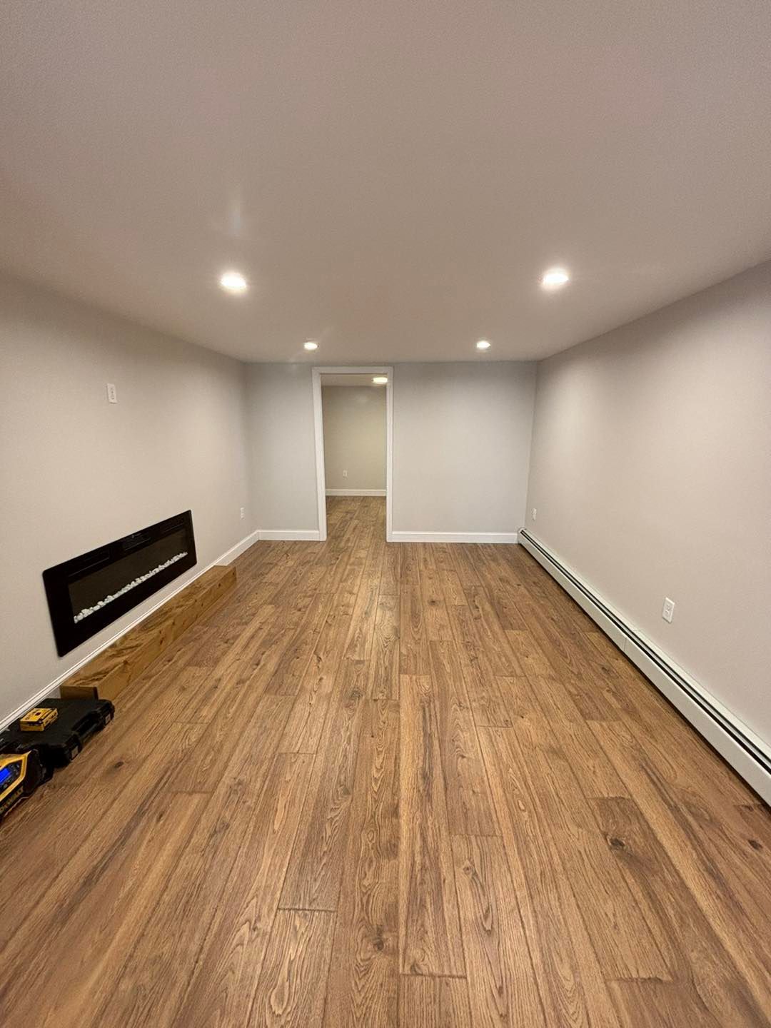 A large empty room with hardwood floors and a fireplace.