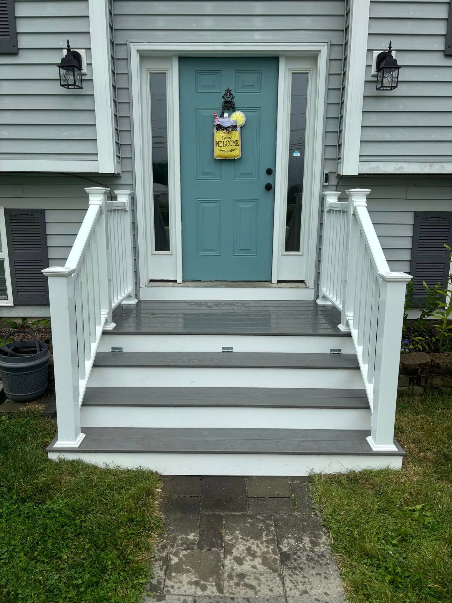 The front door of a house with a blue door and white steps.