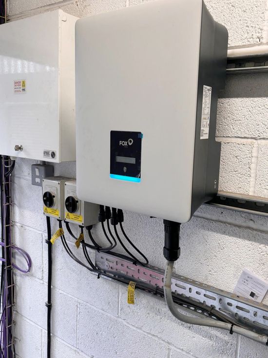 Wall-mounted electrical control panel with digital display and conduit in a utility room