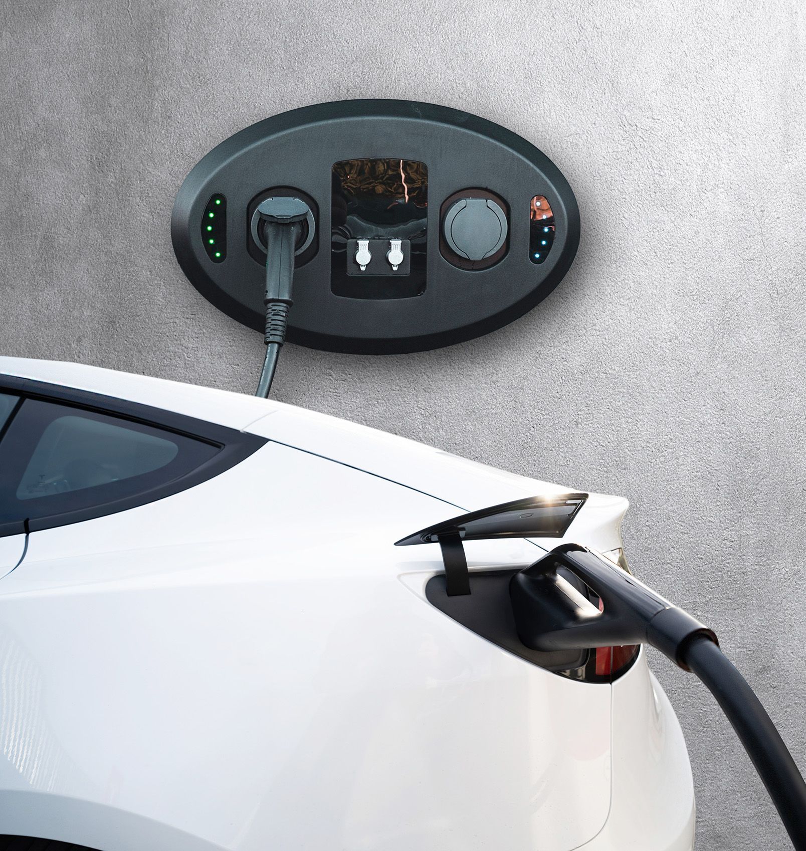 White electric car charging at a wall-mounted charging station with a plugged-in cable