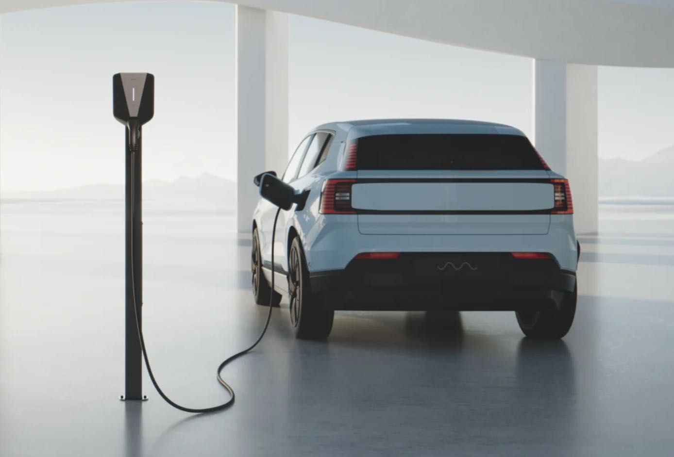 Wall-mounted EV charger with connected cables, white and black units on a plain wall