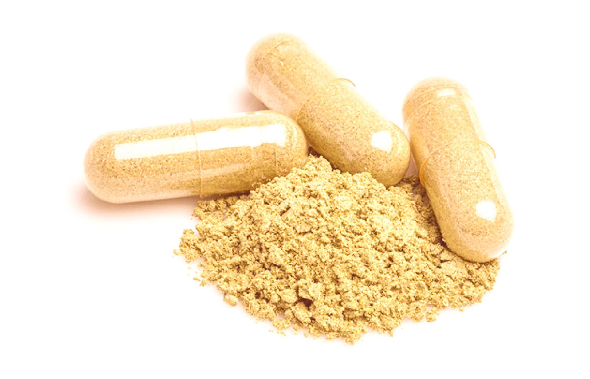 Three beige capsules beside a pile of light brown powder on a white background