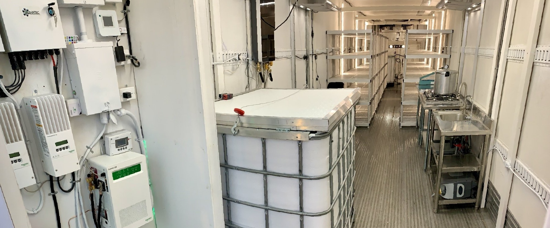 Industrial corridor with electrical equipment and white storage tanks in a bright utility room