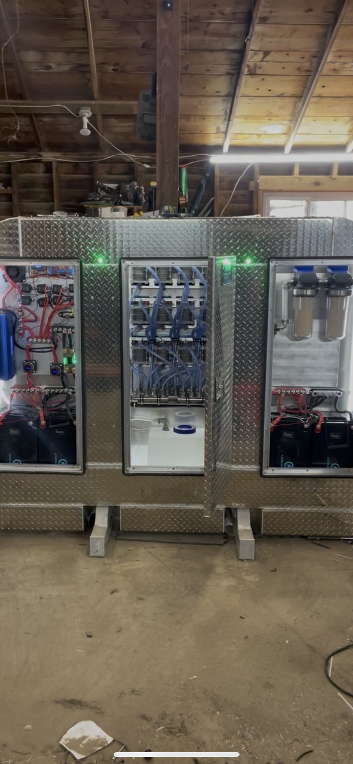 Three vending machines lined up in an indoor industrial-style space with exposed beams and concrete floor
