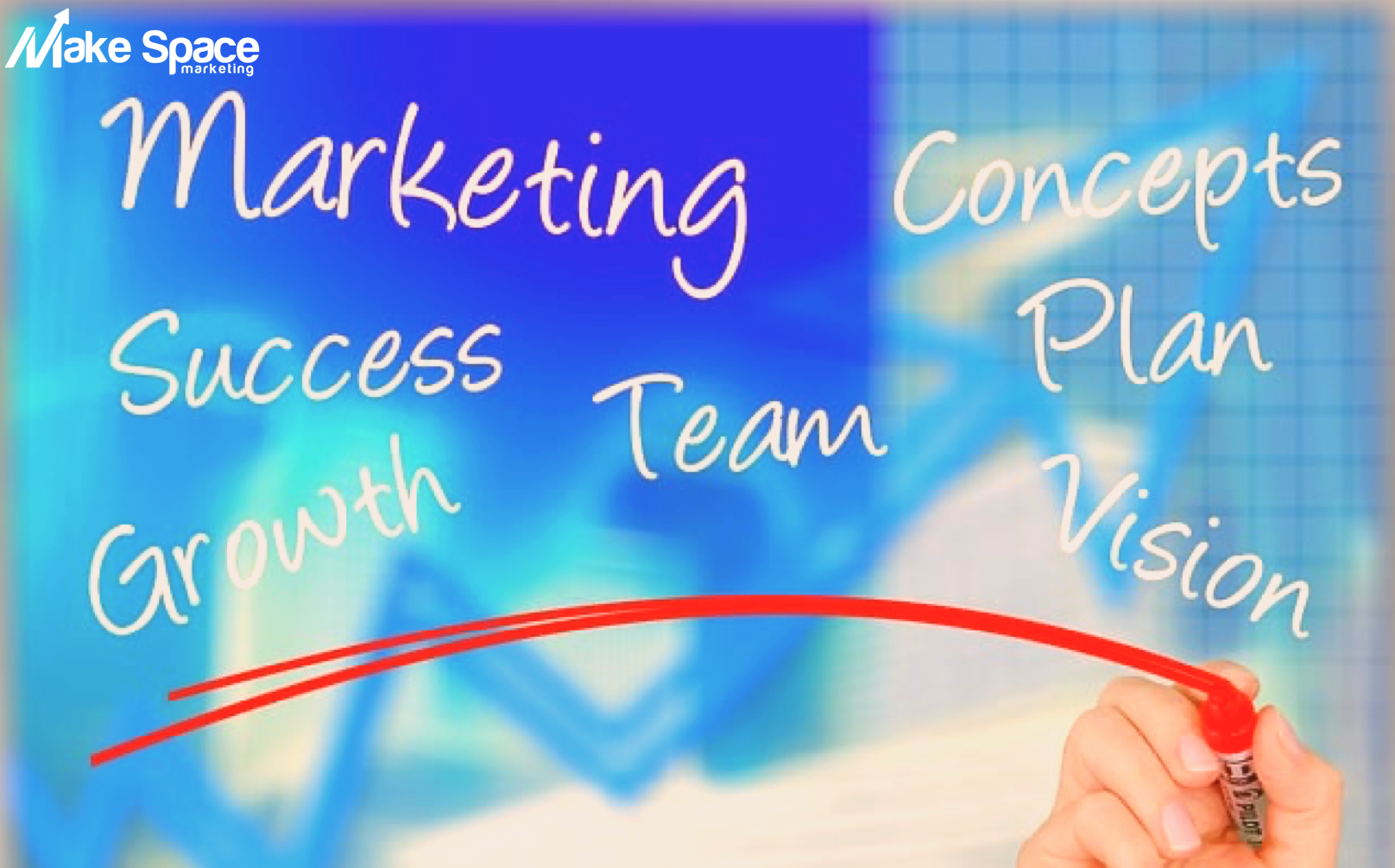 A person is writing marketing concepts success team growth and vision