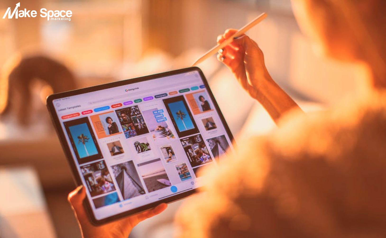A person is holding a tablet with a pen in their hand.