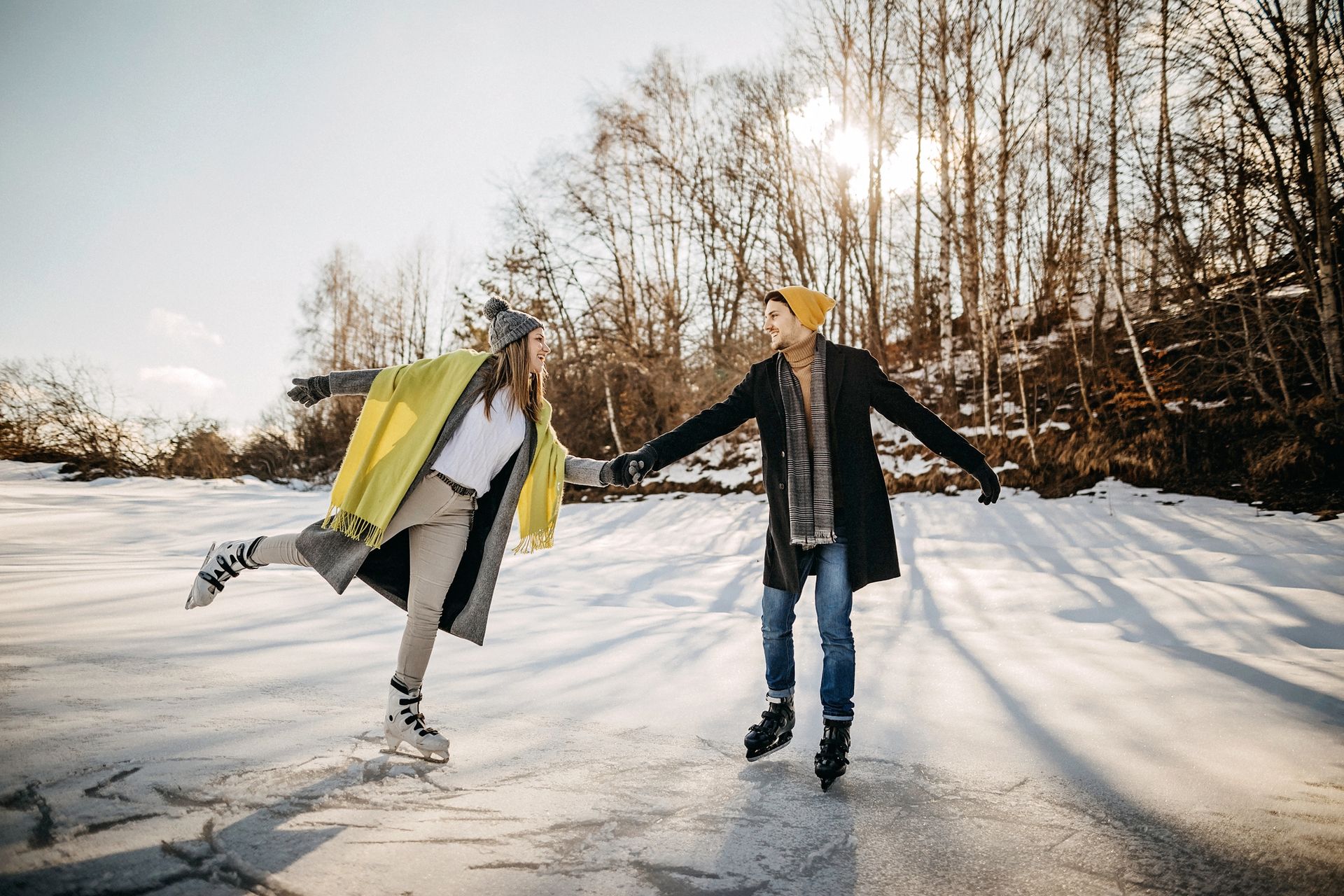 a couple ice skating on a frozen pond