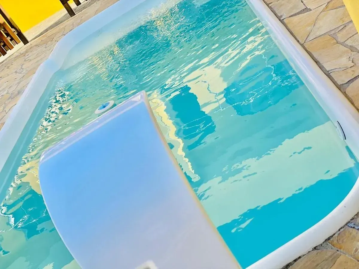 Boia inflável em água turquesa ao lado de uma borda branca da piscina.