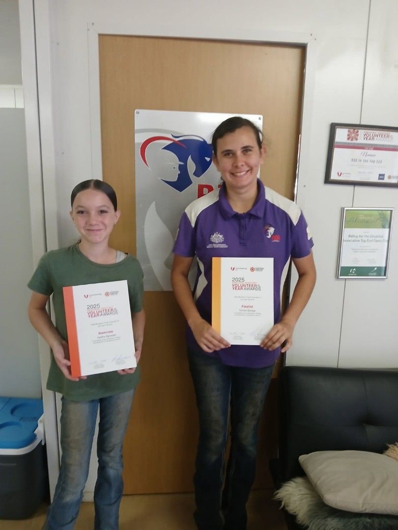 A man and a girl are standing next to each other holding certificates