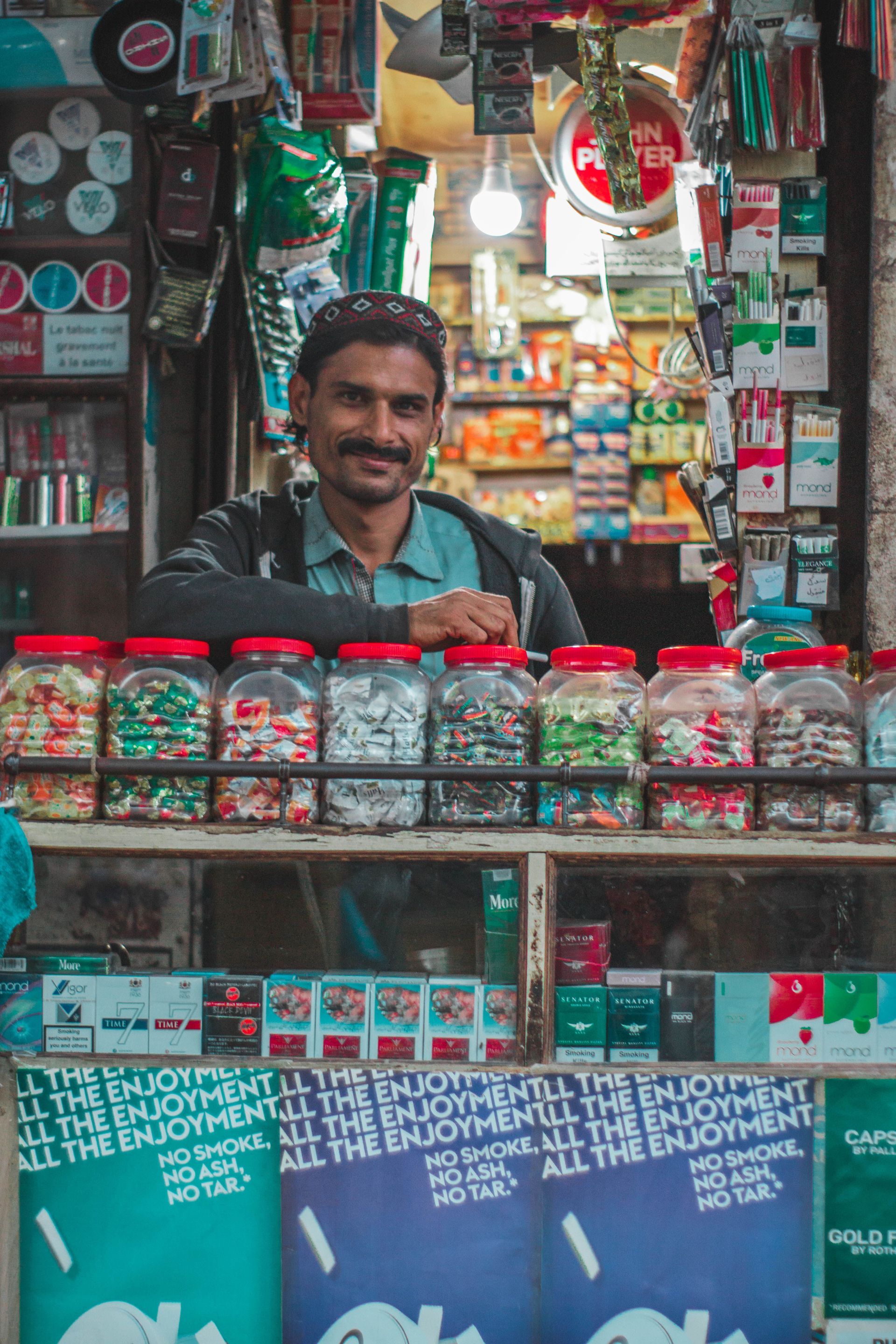 Comerciante na porta da loja de bairro, negócio local pronto para criar o perfil no Google