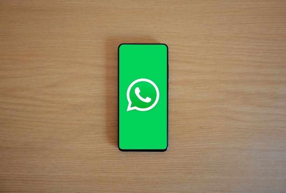 Dono de pequeno negócio usando o celular atrás do balcão da loja