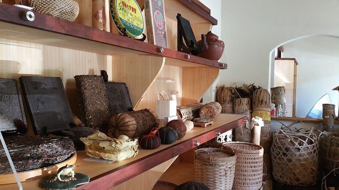 Shelves of woven baskets and crafts in a cozy market shop, with a mirror and wicker stools nearby