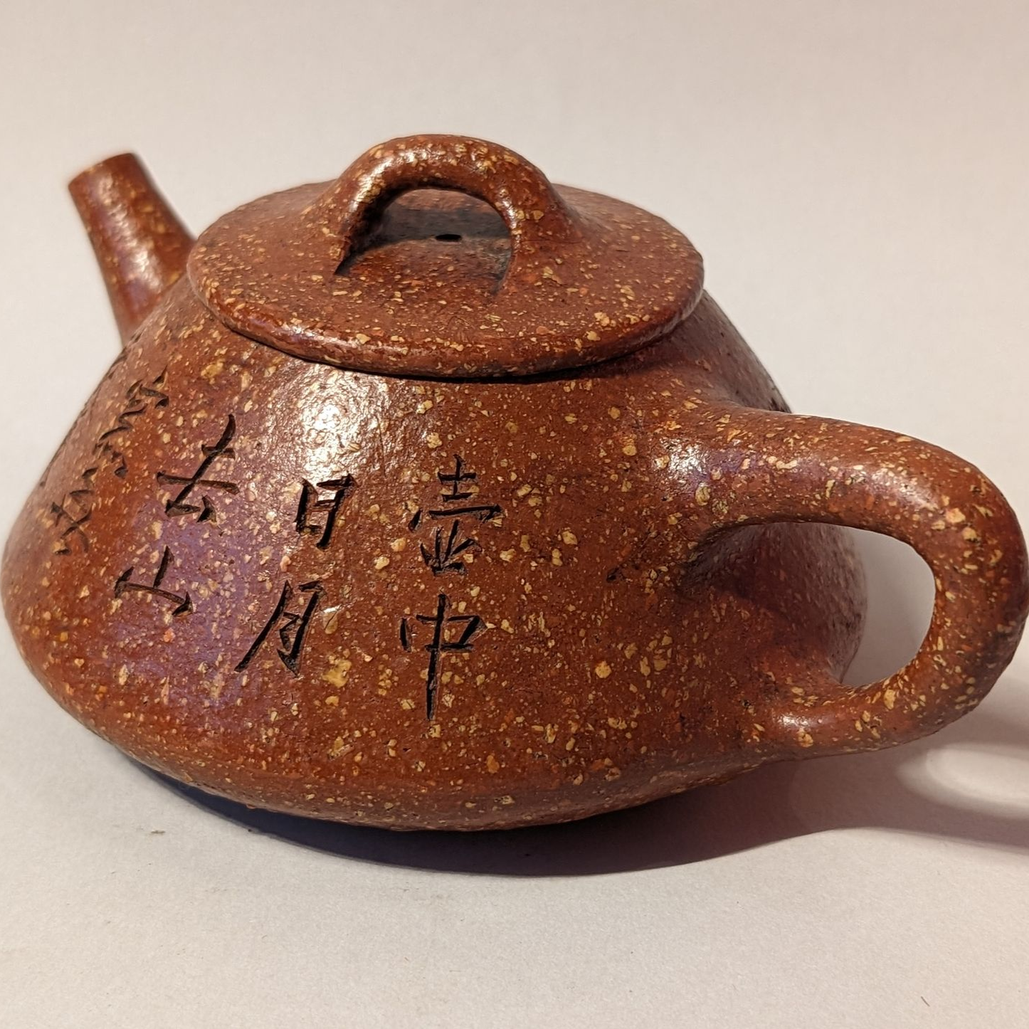 Brown clay teapot with lid, side handle, and vertical black Chinese characters